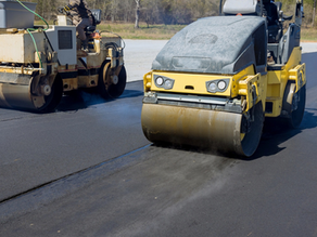Commercial parking lot paving crew resurfacing asphalt.