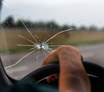 Broken windshield of a car. A web of radial splits.