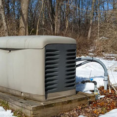 A closed standby generator installed outdoors on snowy ground