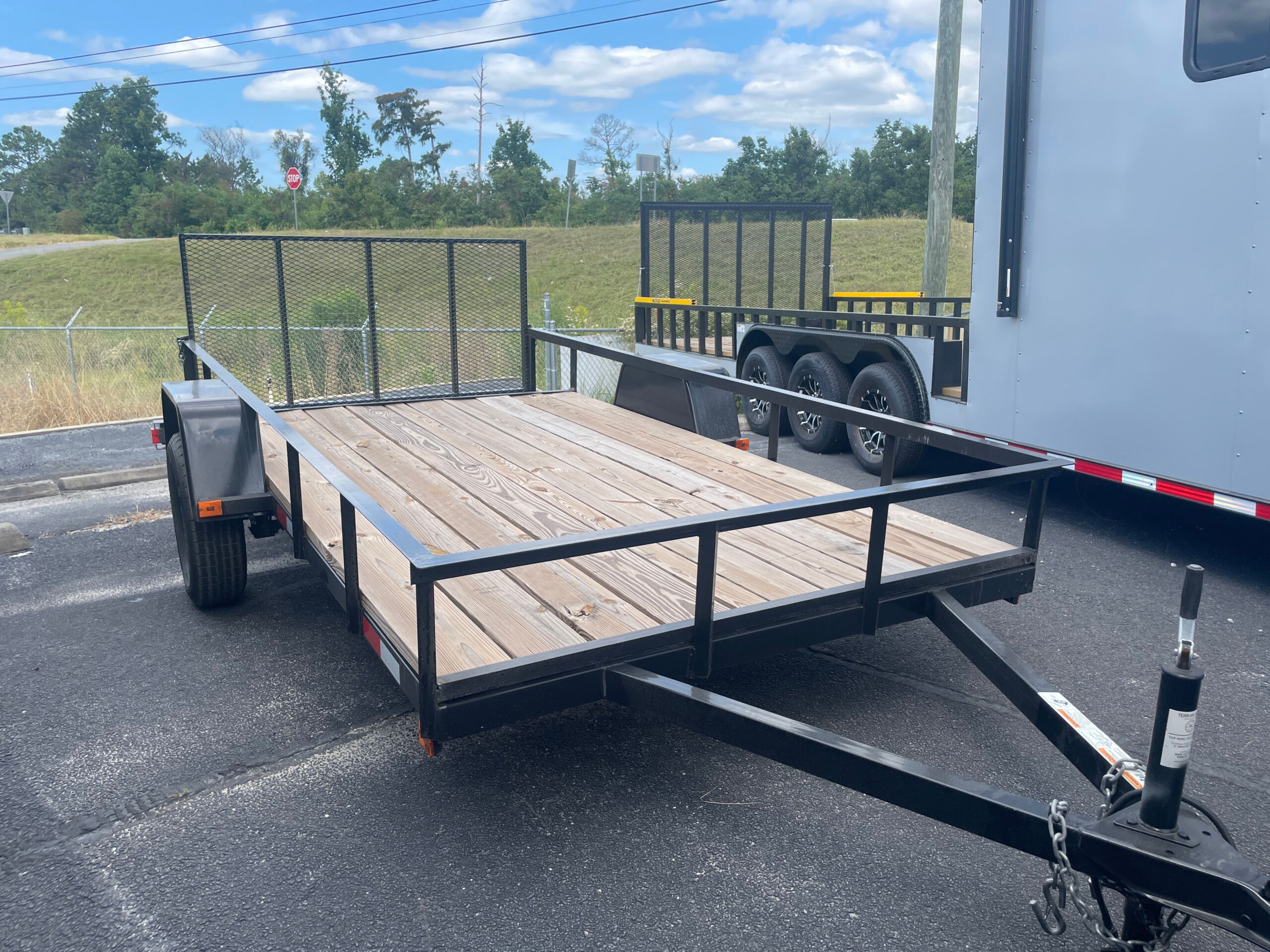 Midsouth 7x14 single axle utility trailer with fold-up gate, dovetail, treated wood floor, and black steel frame.