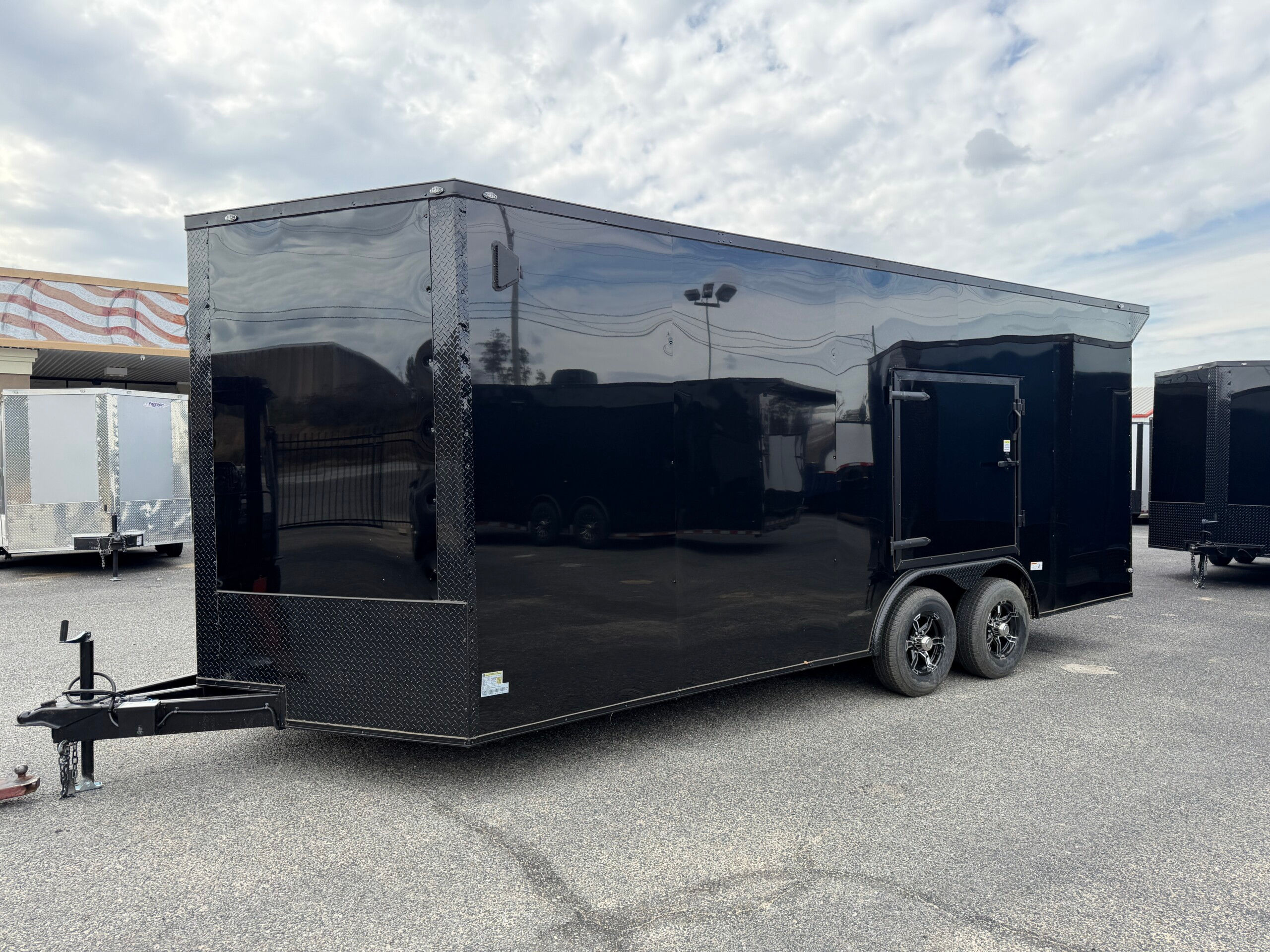Deep South 8.5x20 tandem axle enclosed cargo trailer with white Polycore exterior, blackout package, alloy wheels, escape door, rear spoiler with LED light, and heavy-duty ramp door