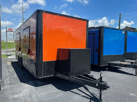 Quality Cargo 8.5x22 orange food trailer with dual concession windows, 8-foot hood, generator box, and commercial kitchen package for sale.
