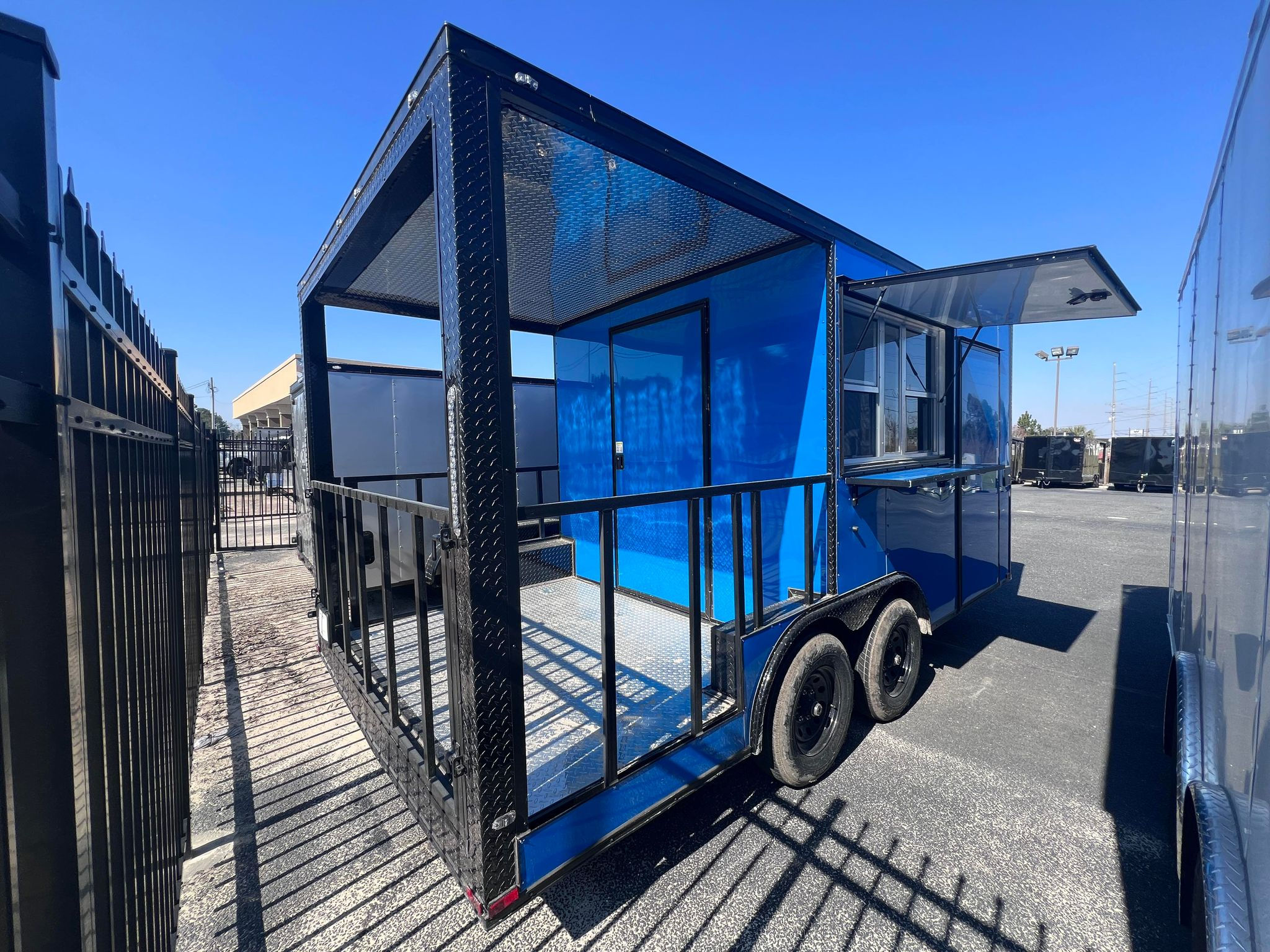 Quality Cargo 8.5x16 Piedmont Blue BBQ trailer with 6-foot porch, blackout package, concession window, and 3-basin sink package, FOR SALE.