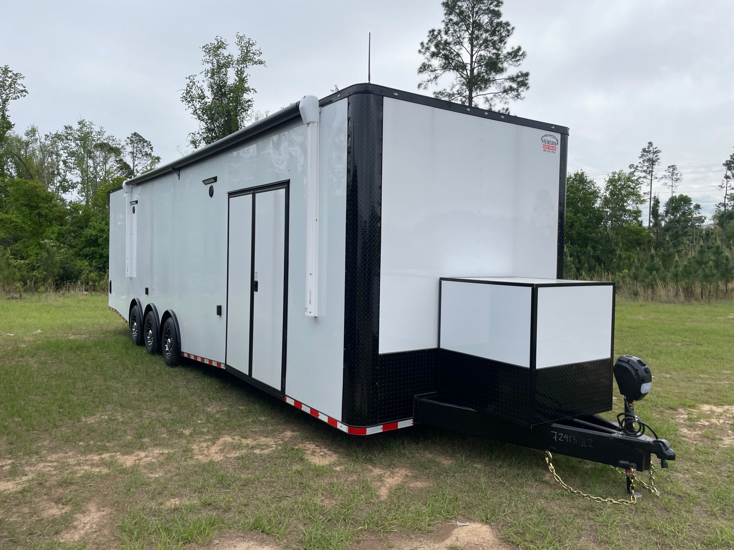Rock Solid Cargo 8.5x34 triple axle race car trailer with white exterior, spread torsion axles, electric awning, generator compartment, RTP flooring, and premium race package.