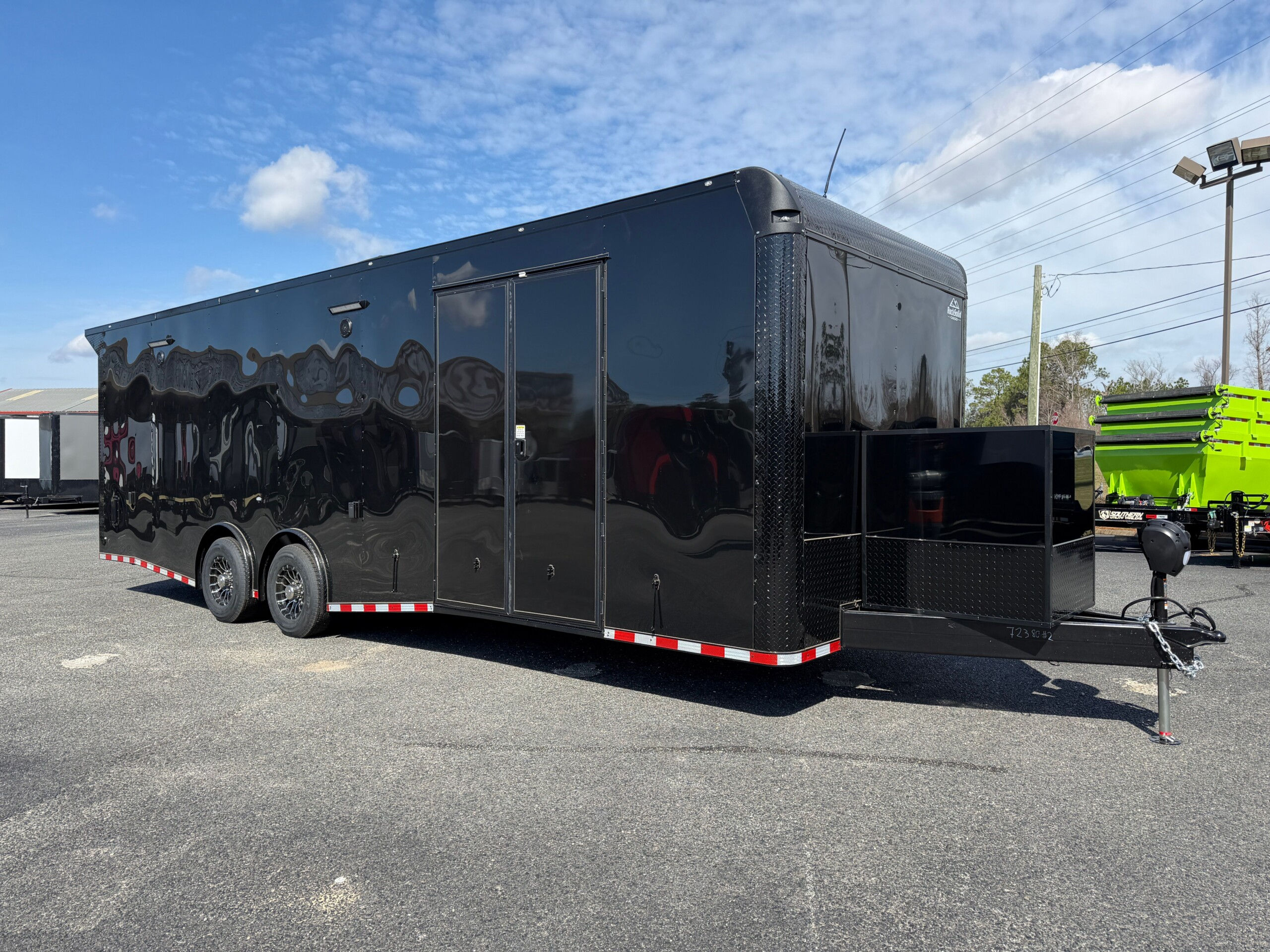 Rock Solid Cargo 8.5x28 blackout race car trailer with black poly exterior, spread torsion axles, escape door, generator compartment, and premium race package.