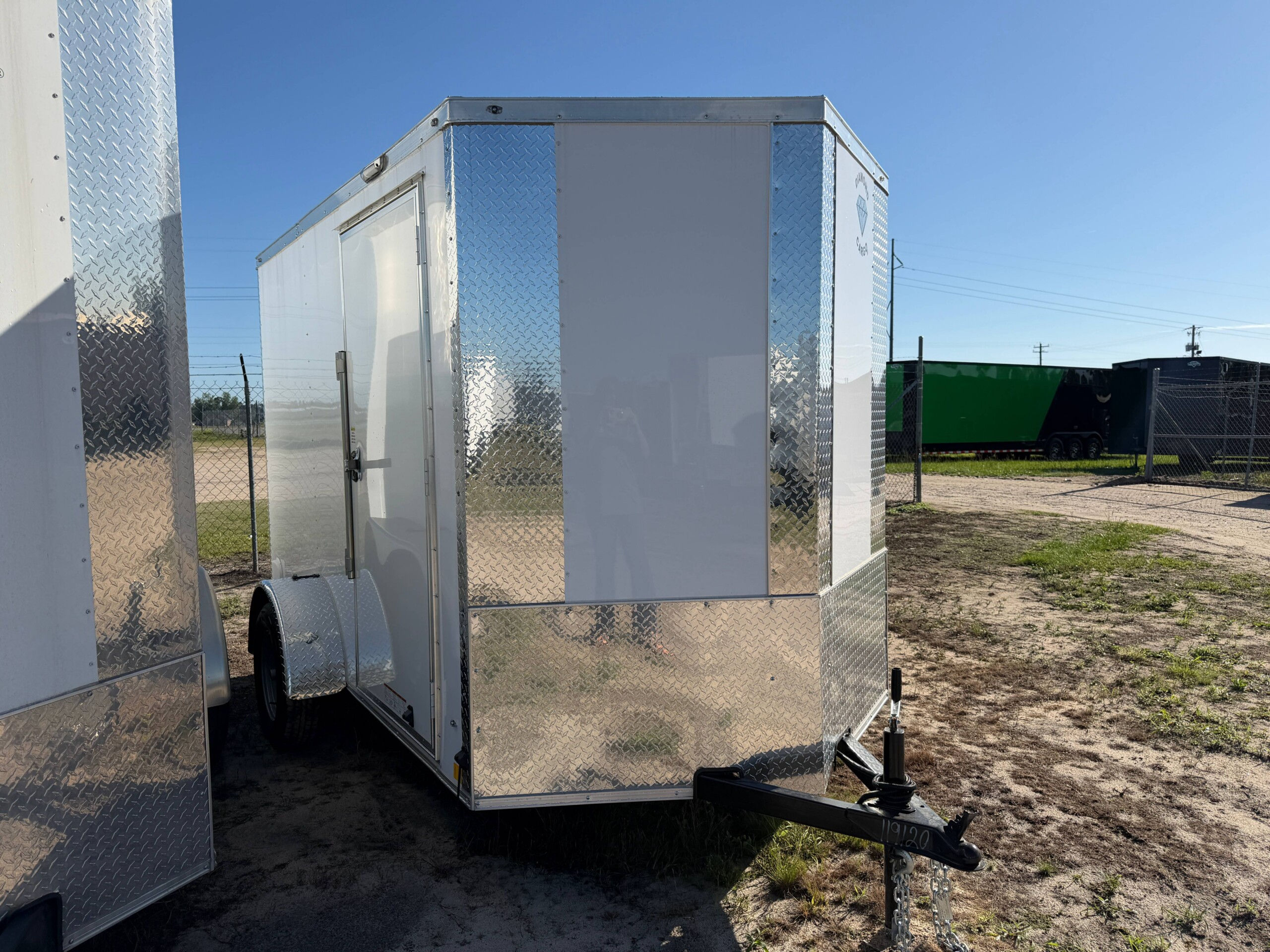 Diamond Cargo 5x10 enclosed cargo trailer with Polycore exterior, V-nose design, ramp door, LED lights, and silver modular wheels.