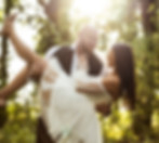 homepage picture of groom holding his fiance in a beautifully lit forest