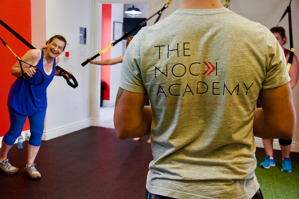 High angle view of a trainer demonstrating a kettlebell swing to a small group