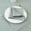 Thumbnail: Light sage green linen napkin folded on a white plate with gold cutlery.