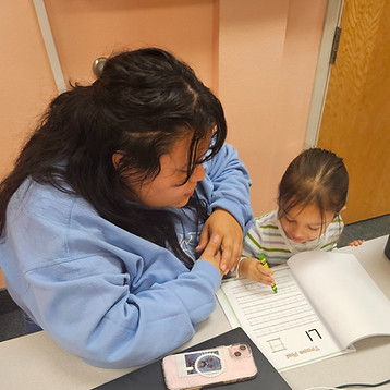 Teacher helping a student write the alphabet