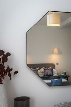 Contemporary interior detail reflected in a geometric wall mirror