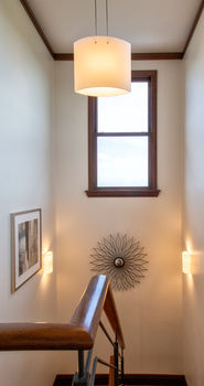 Warm interior detail with pendant light beside a window