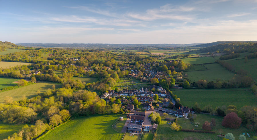 Golden-hour aerial view across village and surrounding landscape