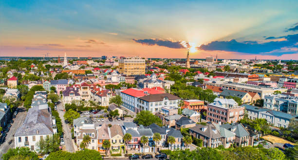 Aerial view of a colorful cityscape at sunset, with historical buildings and a vibrant sky. The warm light creates a peaceful ambiance.