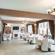 Sala de evenimente cu mese aranjate, scaune albe si semineu max international rasnov