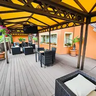 Terasa acoperita cu pergola galbena, mobilier de ratan si plante la Rasnov