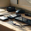 Portable power banks, cables, and a wall charger on a desk with a phone charging.