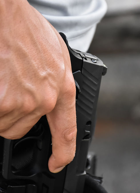 Photo of a hand holding a gun in a holster