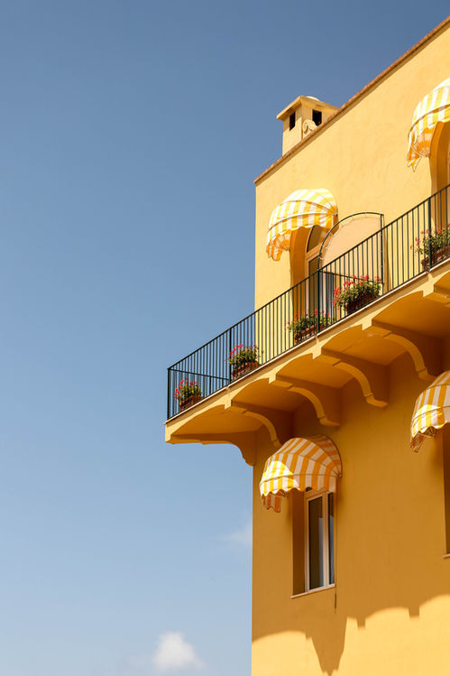 Capri allure: A yellow building stands against the vivid blue sky on the charming island of Capri, Italy