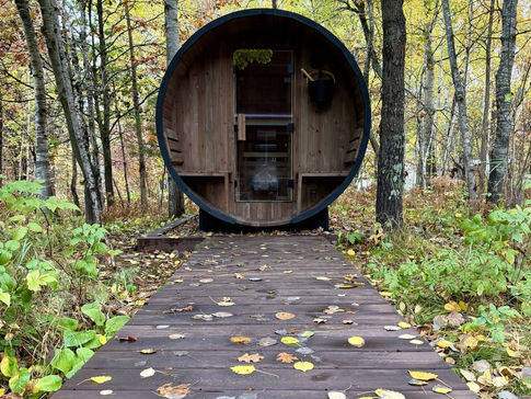 Cedar barrel sauna at the end of a wooden boardwalk in the woods at True North, Nisswa, Minnesota