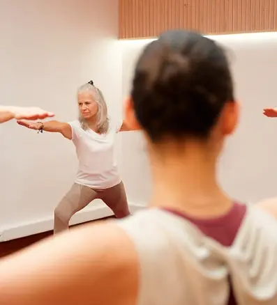 Cours de Yoga à Paris au studio de Yoga Home Yoga Paris proche du 8e, 16e, 17e arrondissement. Femme dans la posture du Guerrier II ou Virabhadrasana II