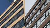 Close-up of dirty hospital exterior windows with years of mineral deposit buildup before drone cleaning at UCHealth Memorial Hospital