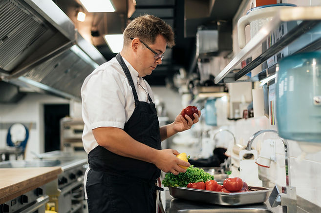 side-view-chef-with-apron-checking-vegetables-kitchen.jpg