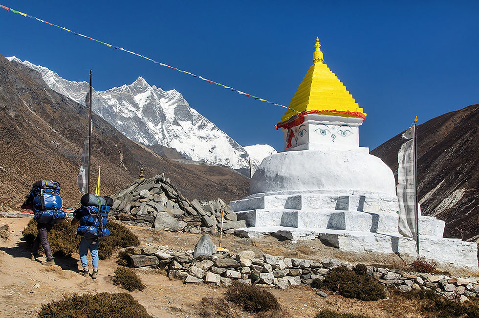 Two Sherpas on their way to Mount Everest base camp pass a Stupa – a sacred, dome-shaped B