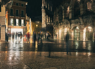 A town square at night with blurred people moving around