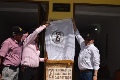 Personas sosteniendo un pendón con el logo de fedecacao