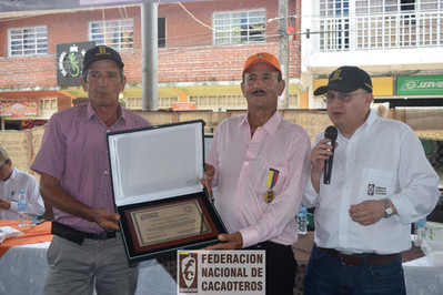 Persona recibiendo una condecoración por parte de fedecacao