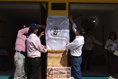 Personas sosteniendo un pendón con el logo de fedecacao
