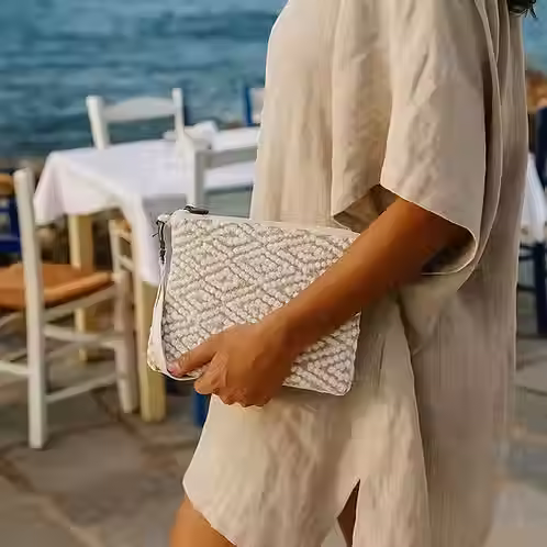 Person holding a patterned clutch bag