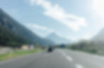 A van on a long road through the mountains, symbolizing the discomfort of holding pee during potty training when a bathroom isn’t available.