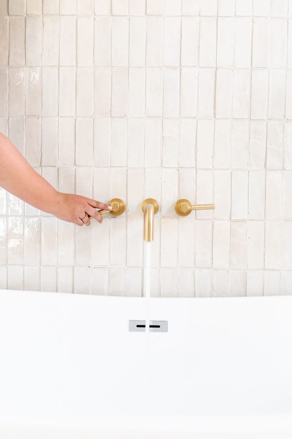 Close-up of a bathroom faucet with modern handles, symbolizing how water play helps toddlers relax and release pee during potty training.