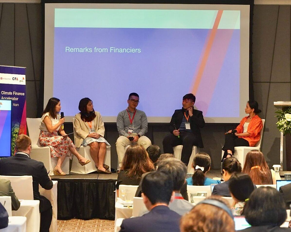 Panel of five people seated on stage discussing climate finance. Screen behind reads "Remarks from Financiers." Audience in foreground.