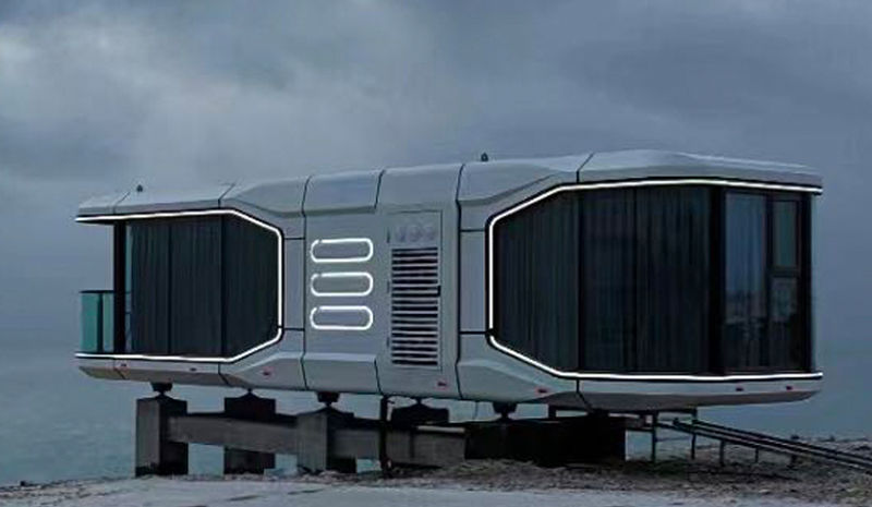 Futuristic capsule house by ViewBox installed on elevated foundation in a remote snowy landscape, featuring panoramic glass windows and LED lighting accents