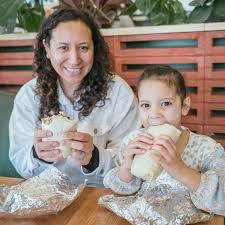 A mother and daughter enjoying some delicious Dubai burritos at a popular restaurant in Austin