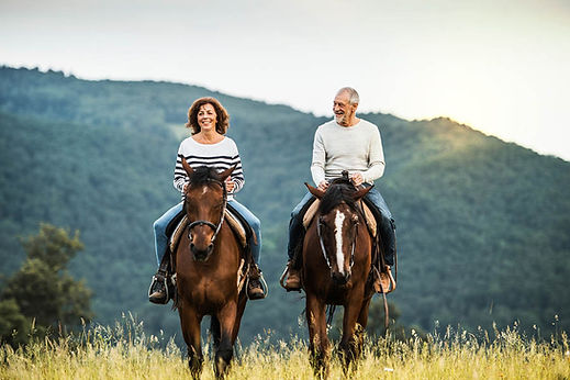 An elderly man and woman, shown here not smoking or drinking alcohol while riding horses across their family estate