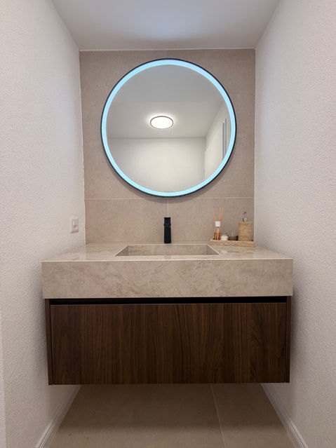 Waschtisch aus dunklem Holz mit Dekton Arga Becken, schwarzer Armatur und rundem LED Spiegel in Solothurn.