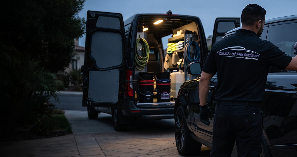 Fully equipped mobile detailing van set up beside a car at a private residence