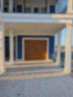 Wood garage door installed on a blue modern house