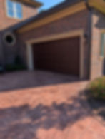 Modern wood-look garage door install on a brick home.