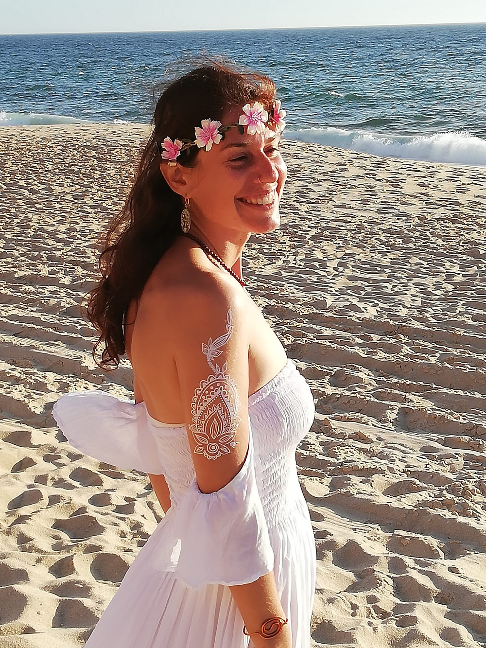 Suzana wearing white and a flower crown at the beach