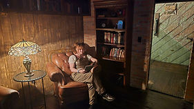 Allison, neurodivergent and queer therapist specializing in LGBTQ+ affirming therapy, eating disorder recovery, and body liberation. Serving clients virtually across Texas, New Mexico, Florida, Idaho, and Arizona. Photo shows Allison in steampunk attire reading in a comfortable leather chair, embodying their authentic, non-conforming approach to therapy.