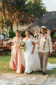 fotografia de novia entrando junto a sus padres a ceremonia de boda frente al mar