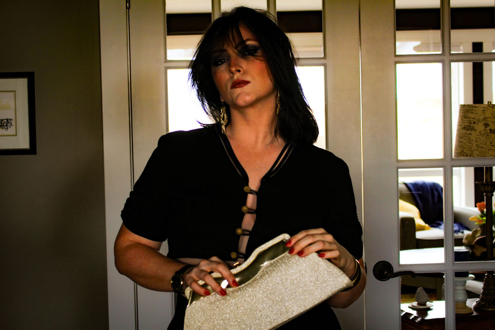 a woman with red nails is holding a white purse