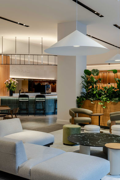 Office reception with coffee bar and lounge seating, lighting design by Ström