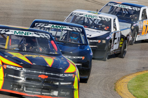 Close up of three trucks racing facing the camera