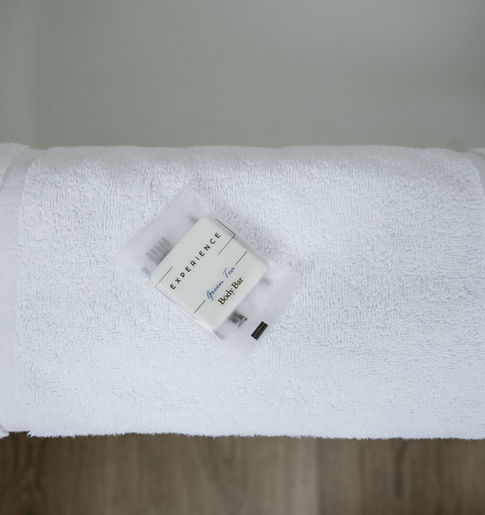 Wrapped body bar on a fresh white towel in hotel room.